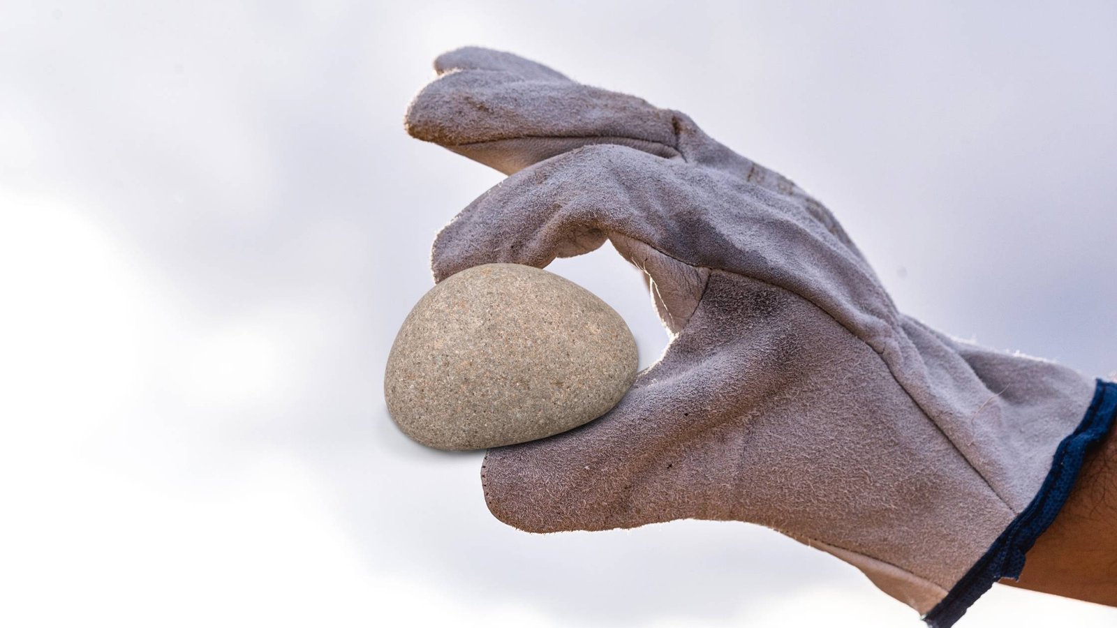 Mano sosteniendo una piedra común, relacionada con la curiosidad sobre trabajos aburridos en China y la búsqueda de piedras valiosas