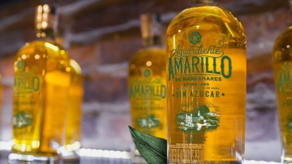 Botellas de aguardiente amarillo colombiano alineadas, representando el posible aumento del precio del aguardiente en Colombia.