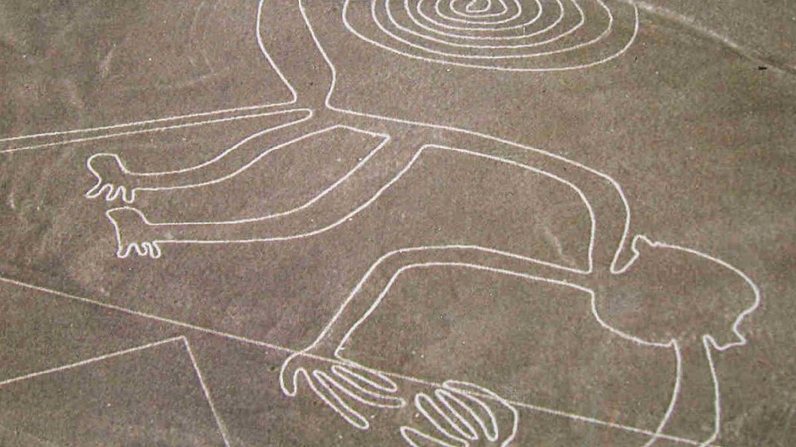 Vista aérea de las Líneas de Nazca en Perú con figuras gigantes dibujadas en el desierto.